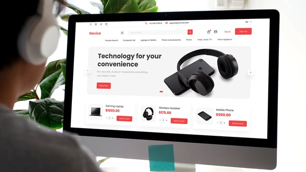 Desktop screen displaying an e-commerce website showcasing products like a gaming laptop, wireless headset, and mobile phone with prices and 'Add to Cart' options.
